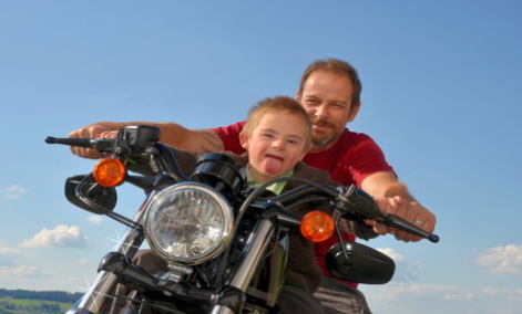 Kind mit Mann auf Motorrad