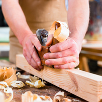 Person arbeitet an einem Stück Holz