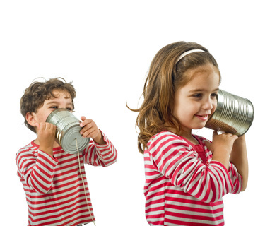 two kids talking on a tin phone