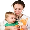 Ärztin mit Kleinkind im Arm und Kuscheltier