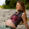 Nachdenkliche schwangere Frau am Strand