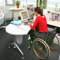 Rollstuhlfahrerin am PC-Arbeitsplatz