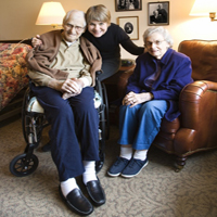 Betreuerin mit zwei Senioren in einer Wohnung